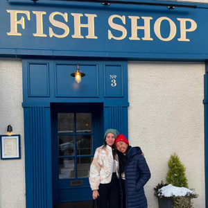 Ria and fellow Fish Shop Leader stand outside fish shop