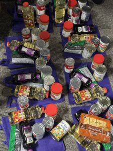 food items are laid out atop the food delivery bags for packaging to Ayuda's clients